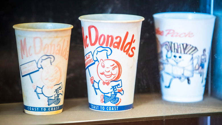 Three vintage McDonald's paper cups with character sketch designs