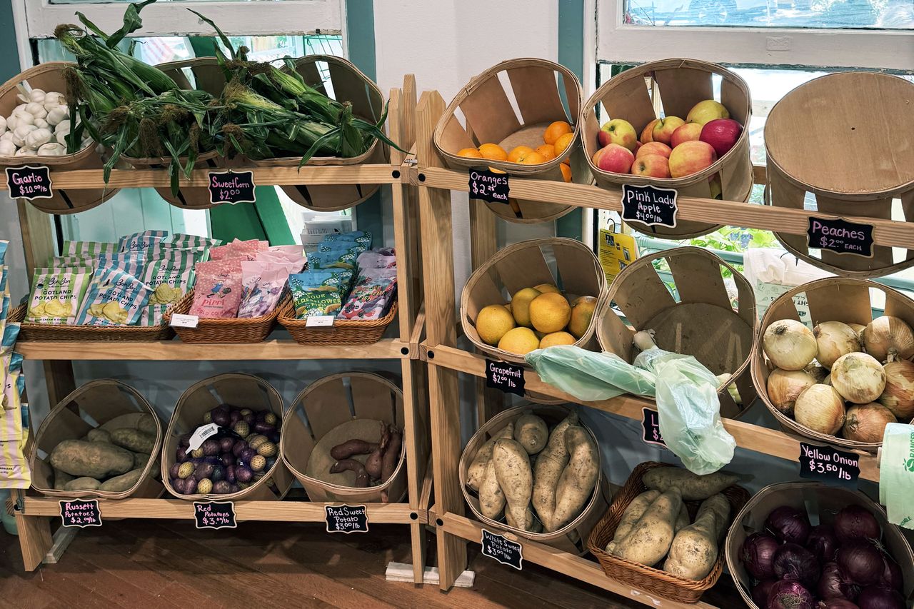 Display of fresh produce and other items on wooden shelves in a store