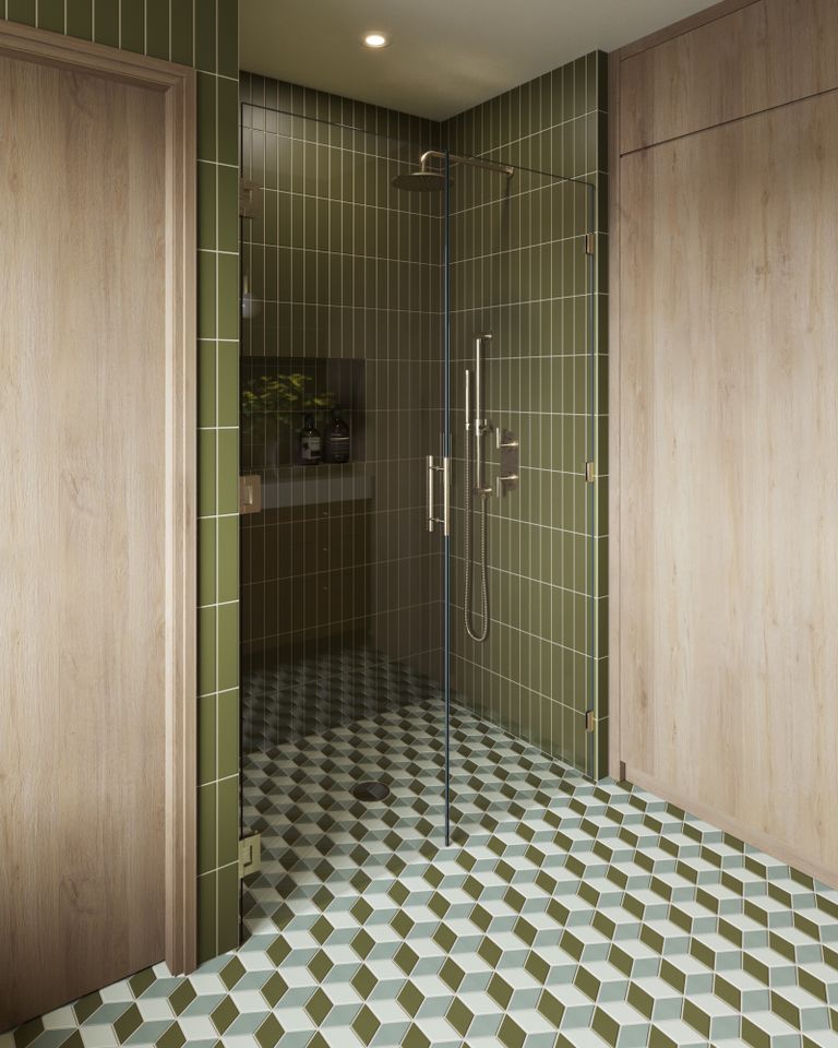 Bathroom with green tiled walls a shower space enclosed with glass and patterned floor tiles