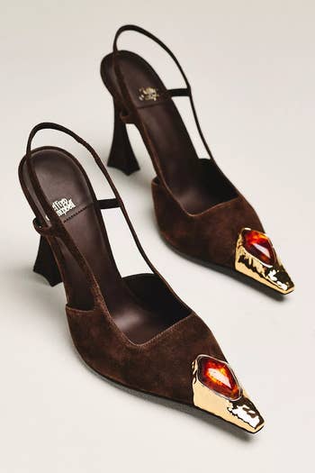 Elegant suede slingback heels with a unique gold and red gemstone accent on the pointed toe, perfect for stylish occasions