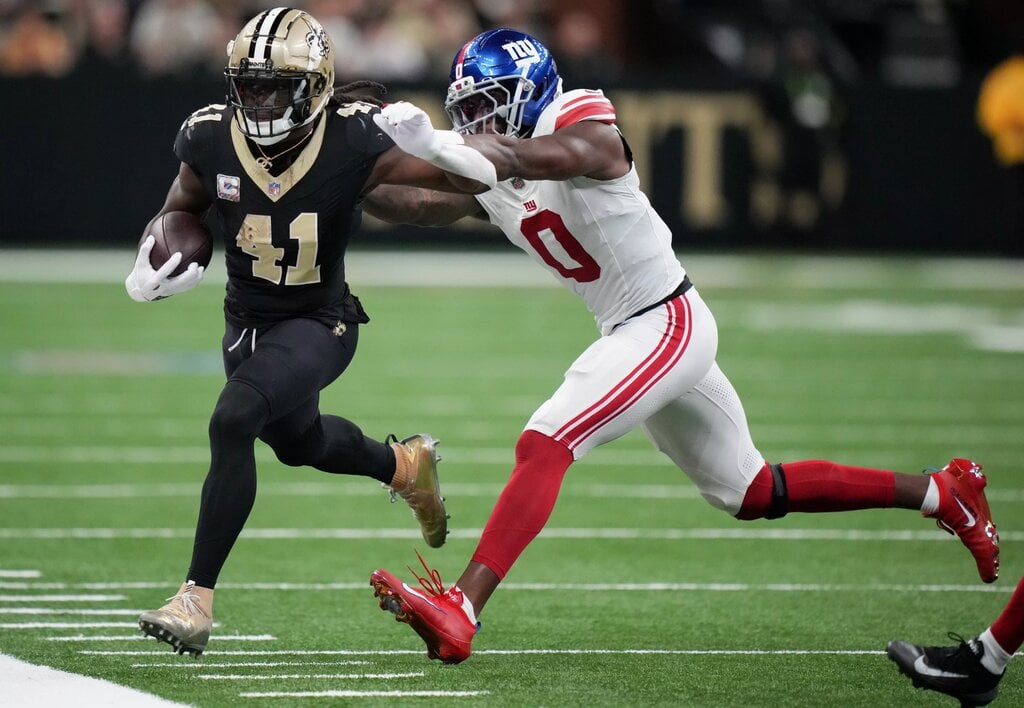 Oct 5, 2025; New Orleans, Louisiana, USA; New Orleans Saints running back Alvin Kamara (41) runs the ball against New York Giants linebacker Brian Burns (0) at Caesars Superdome. Mandatory Credit: Matthew Hinton-Imagn Images