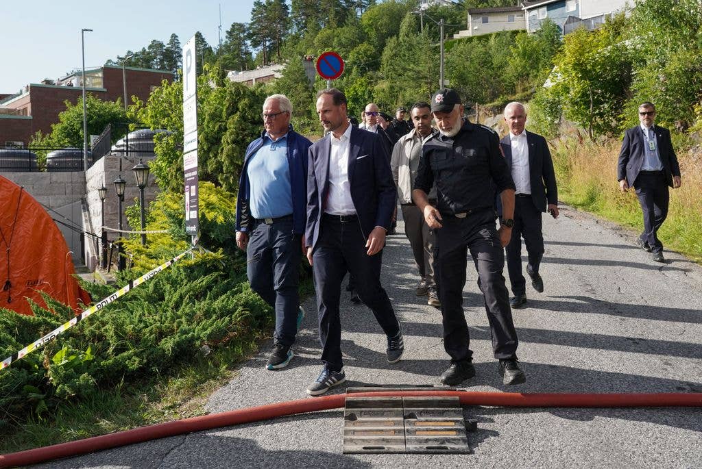 Crown Prince Haakon of Norway inspects the fire site with emergency services and representatives from the municipality's crisis management at the scene of the accident by Krokstadelva