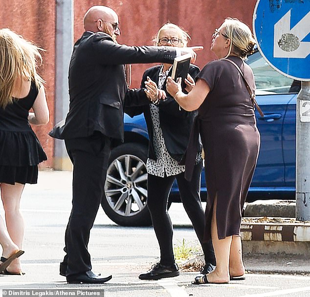 Lewis is challenged by the family (R) of Darcy Ross, who was one of the victims, as he leaves Cardiff Magistrates Court