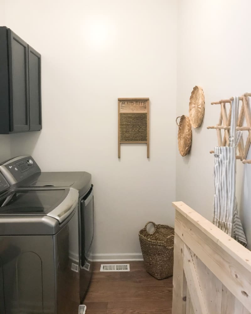 Laundry room with black cabinetry and some boho decor