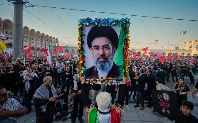 A man holds a picture of Iran’s new Supreme Leader Mojtaba Khamenei at the Imam Khomeini Mosalla Grand Mosque, during funeral ceremonies for slain supreme leader ayatollah Ali Khamenei and members of his family in Tehran, Iran, July 5, 2026. (AP Photo/Altaf Qadri)