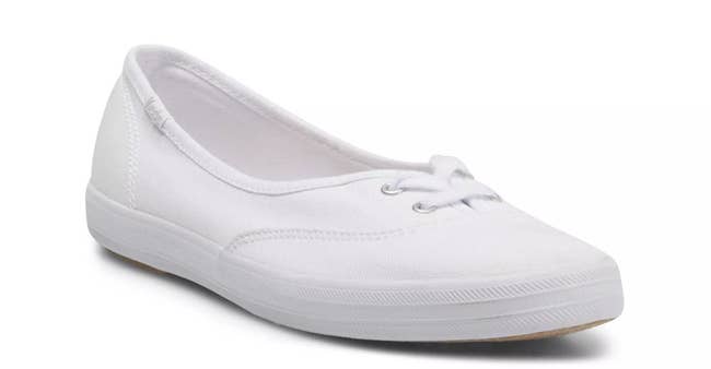 Casual white canvas slip-on sneaker with a low profile and minimalist design, perfect for everyday wear and versatile styling