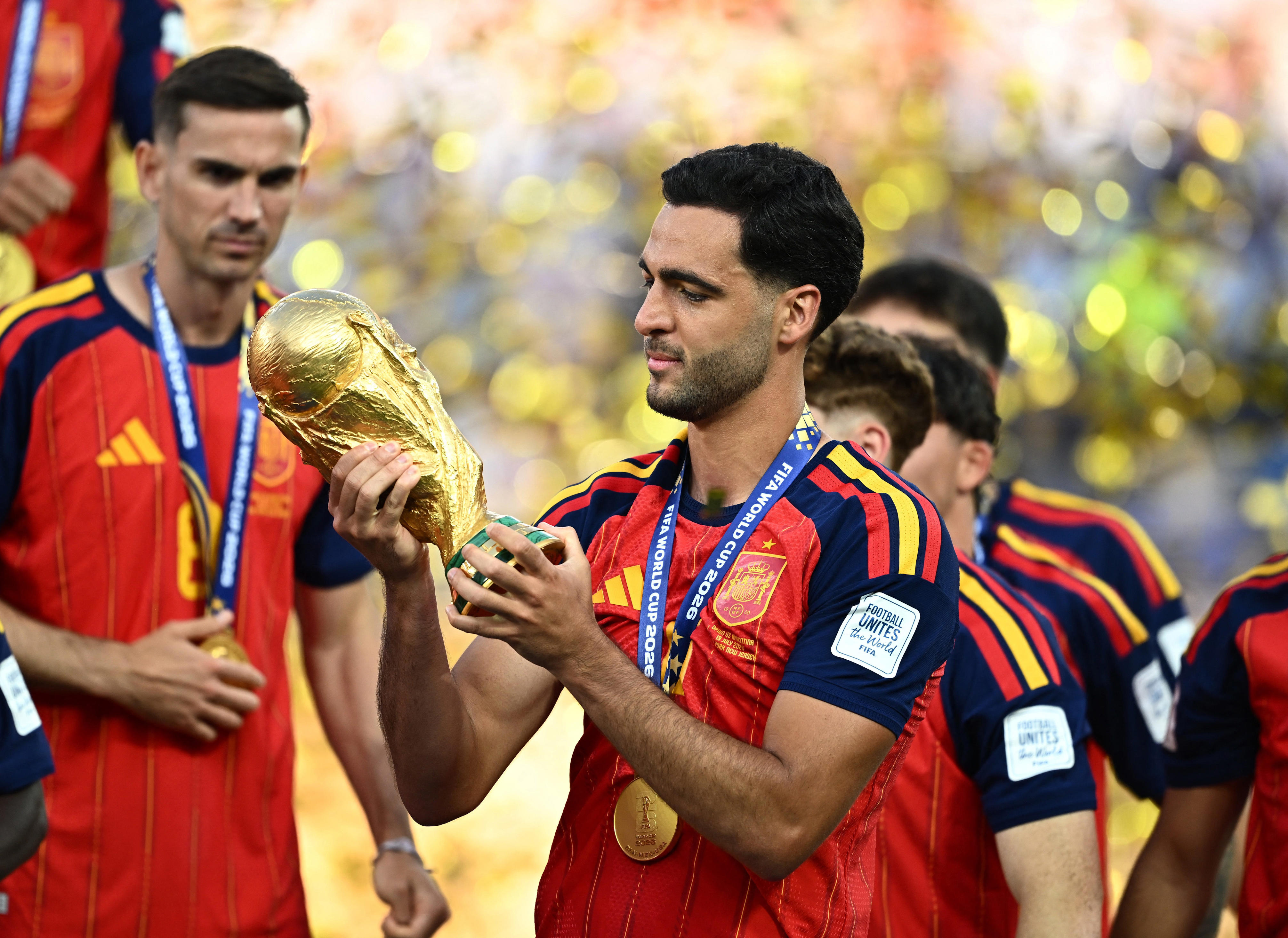 Spain's Mikel Merino holds the World Cup trophy alongside teammates as they celebrate winning the World Cup.