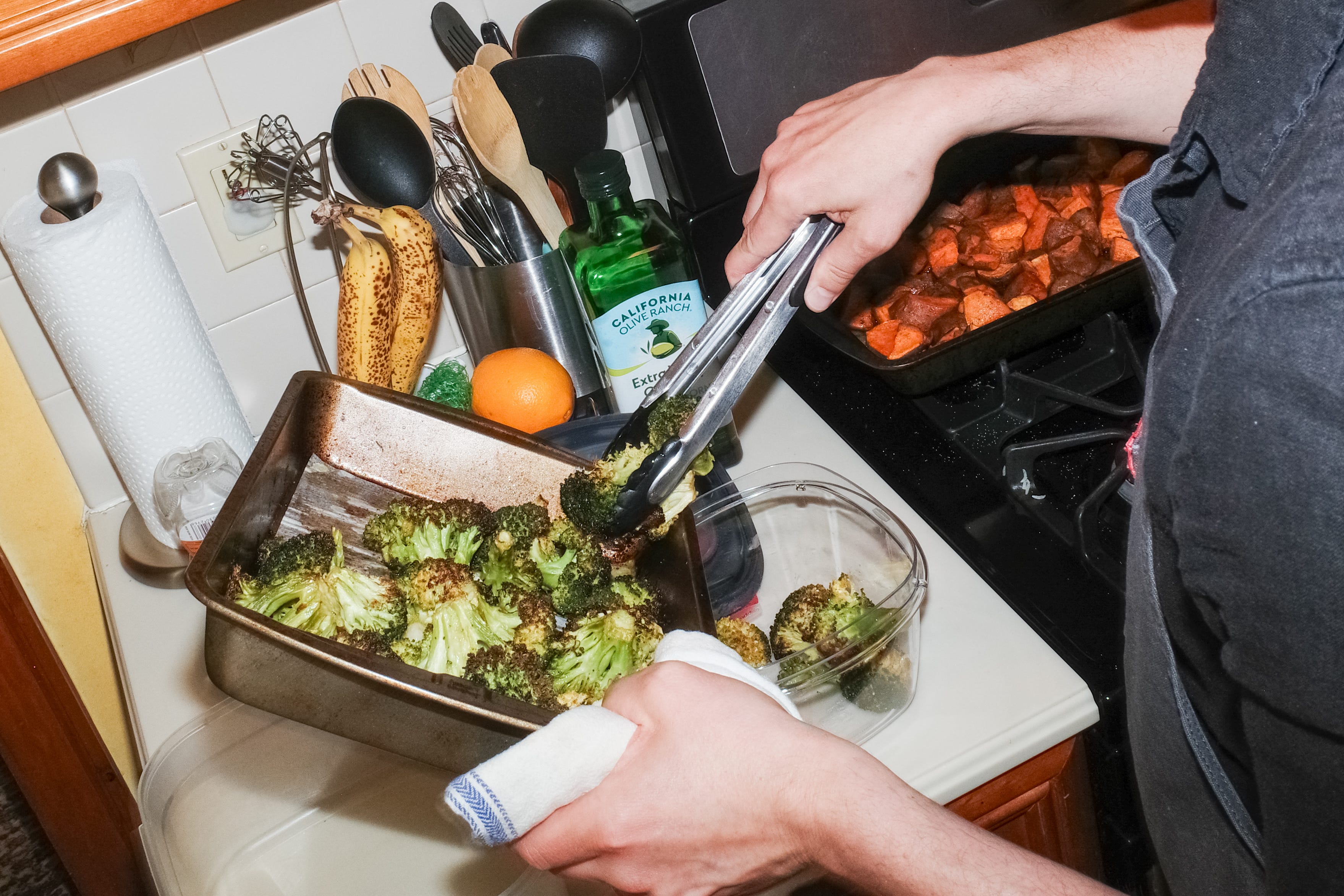 A chef putting broccoli into a bowl