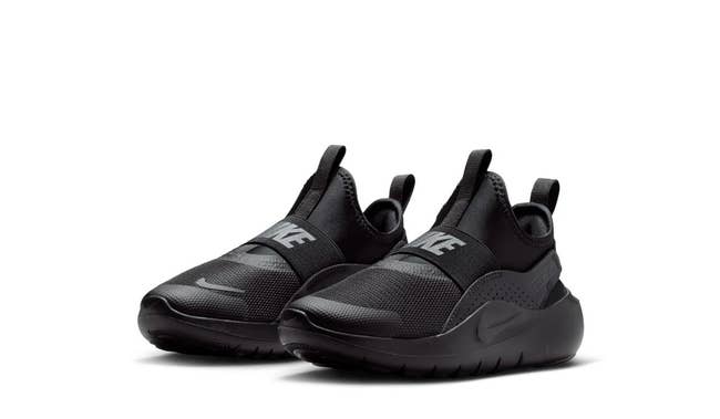 Black slip-on athletic shoes with a sleek design and logo on the strap, ideal for casual wear or workouts