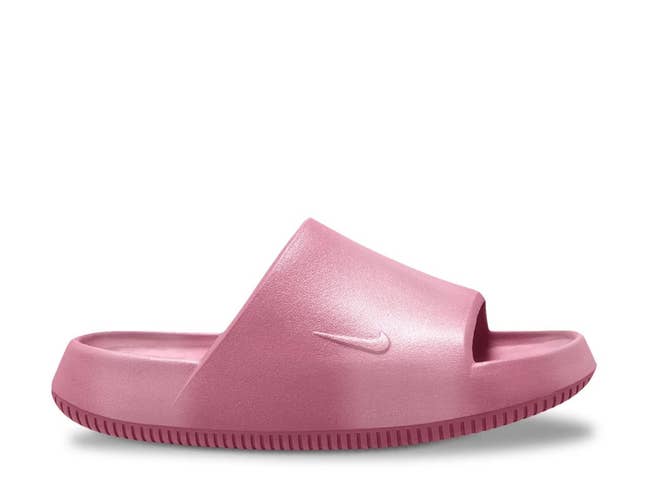 Pink Nike slide sandal with a contoured footbed and open toe design, featuring a subtle Nike logo on the strap