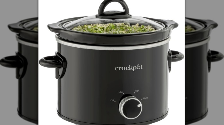 Black slow cooker with green food inside it