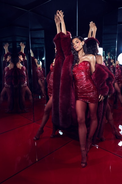 Erika Hammond wearing a red mini dress and red fur standing in front of a mirror.