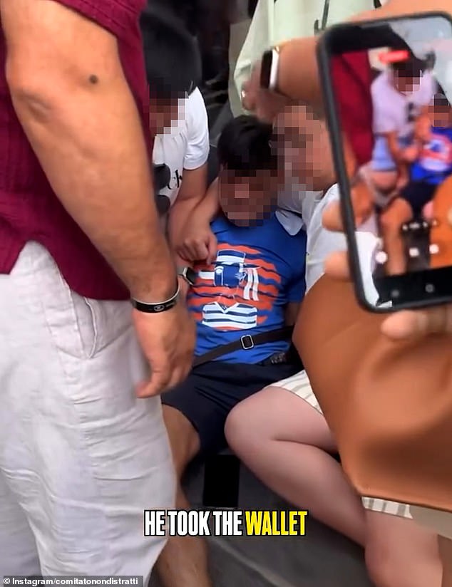 This is the moment a 'pickpocket' was pinned down in the street by furious tourists who rallied together to stop him