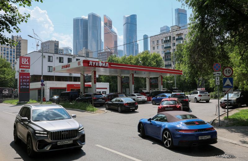 FILE PHOTO: Vehicles queue to refuel at a Lukoil petrol pump in Moscow
