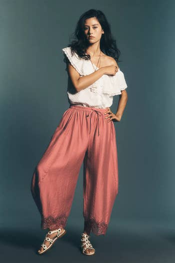 Person poses in boho-style wide-leg pants with lace trim and an off-shoulder top, ideal for a casual summer look