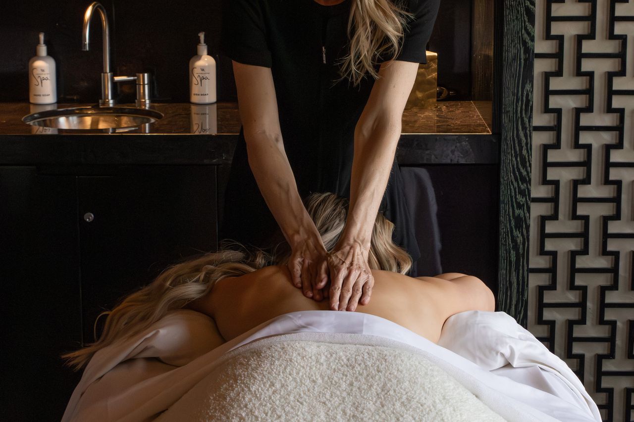 A person receiving a back massage in a spa treatment room