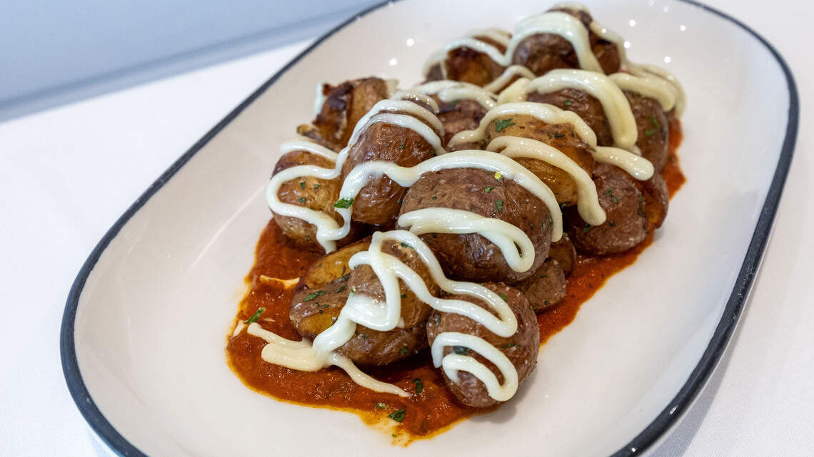 The V at the Vine has redone its menu, featuring a tapas-style, small plate concept including Patatas Bravas ($12). The potato dish is served in bravos sauce and drizzled with garlic aioli.