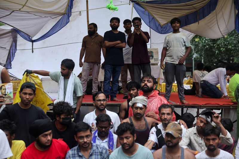 Abhijeet Dipke, head of the Cockroach Janta Party (CJP) stands with injured supporters a day after thousands of protesters marched towards parliament at Jantar Mantar