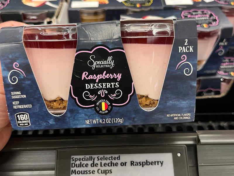 Someone holding package of raspberry desserts in Aldi's.