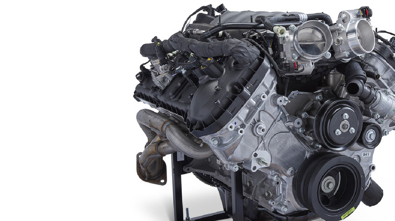 The Ford 5.0-liter Coyote Gen III crate engine on a stand, pictured here on a clean white background with a shadow.