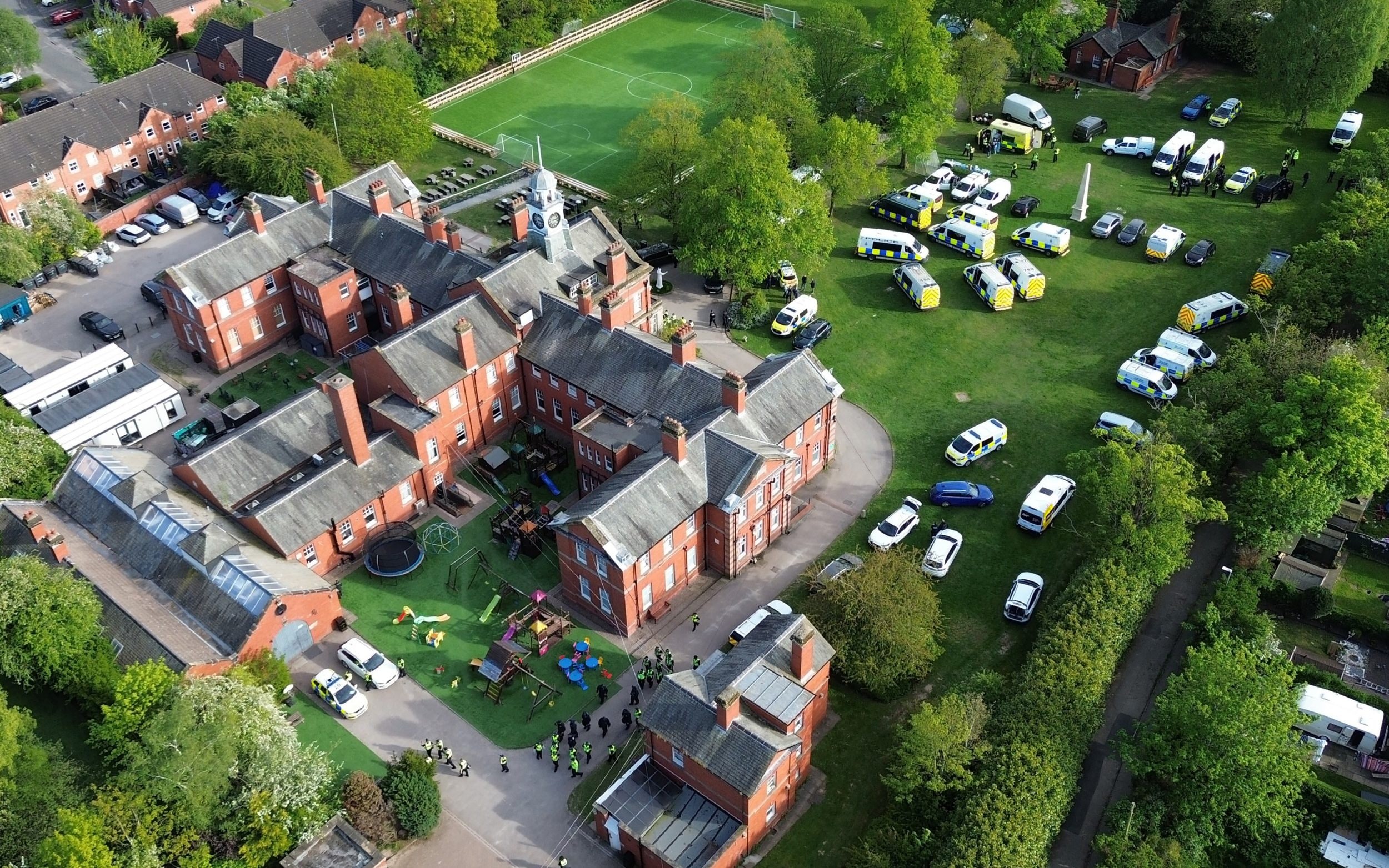 Aerial view of police in attendance at the Webb House compound for the Ahmadi Religion of Peace and Light