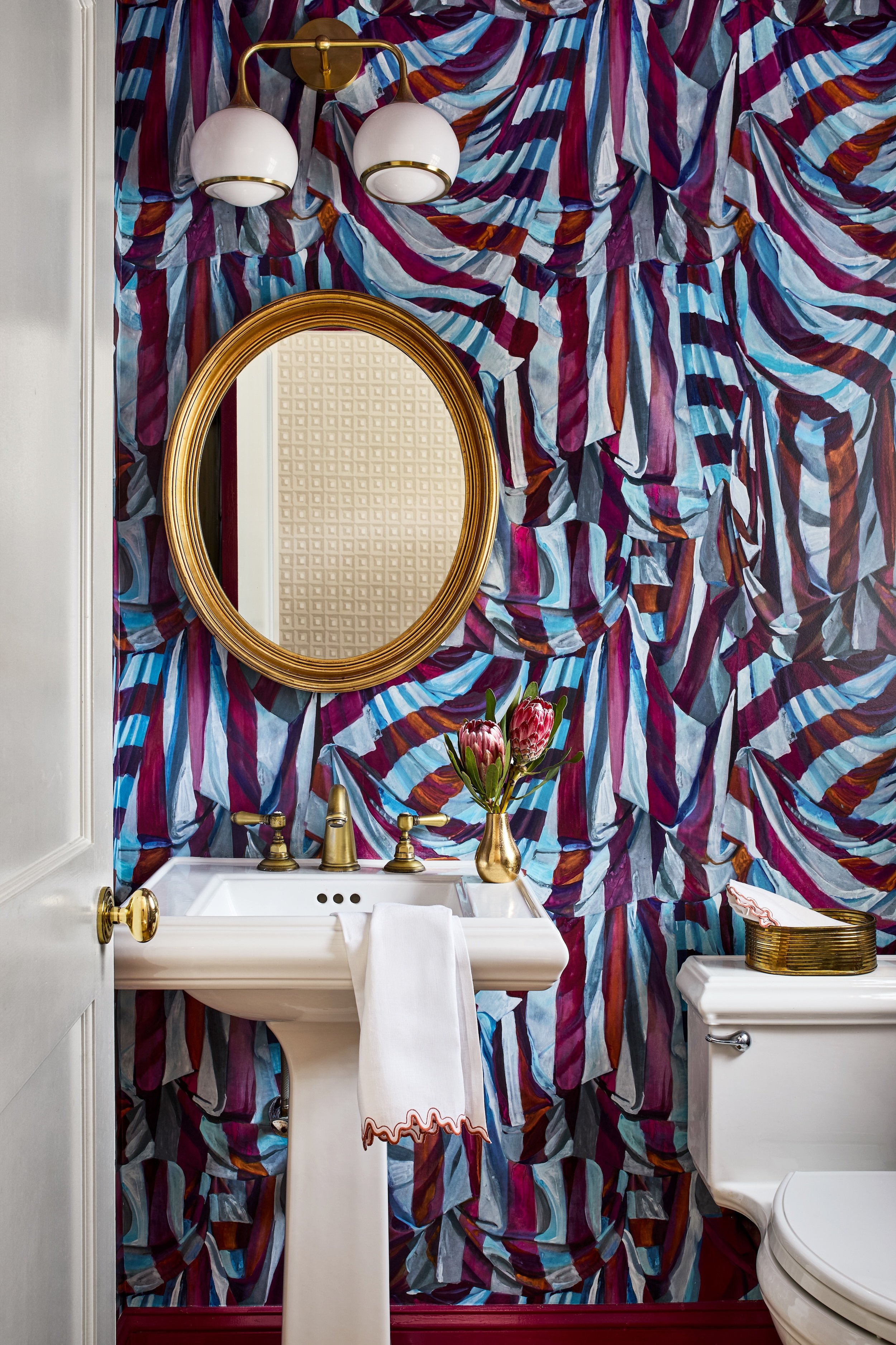 Wallpaper by Voutsa covers the walls and the ceiling of the powder room.