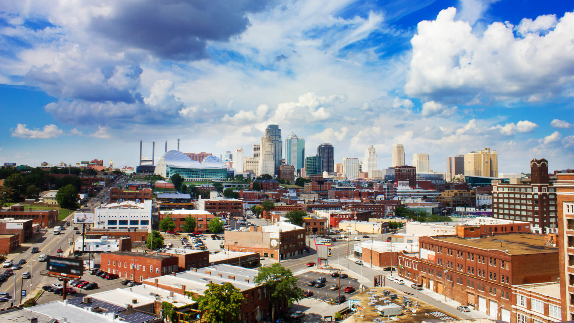 Discover the skyline of downtown Kansas City, Missouri at daytime under a big blue sky with striking clouds
