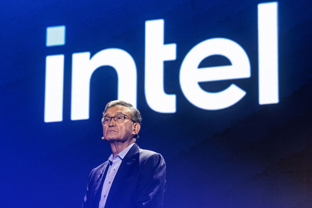 Intel CEO Lip-Bu Tan is seen in front of a screen with the Intel logo on it.