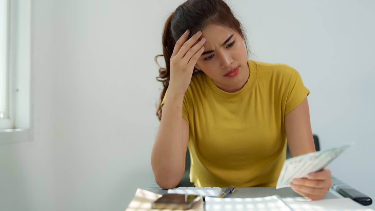 stressed-young-woman-with-calculator-and-paper