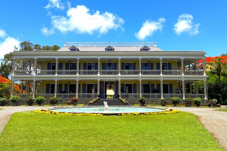 A view of Château de Labourdonnais in Mauritius, showcasing its elegant architecture surrounded by greenery.