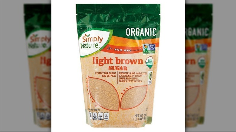 Light brown sugar in a beige and green bag on a white background.