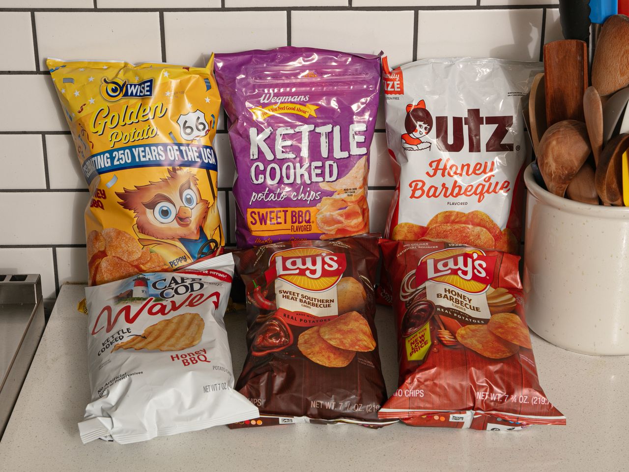 Assorted bags of kettlecooked and flavored potato chips displayed on a kitchen counter