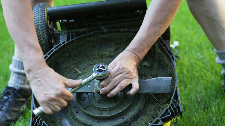 Man tightening retention bolt of mower with a torque wrench.