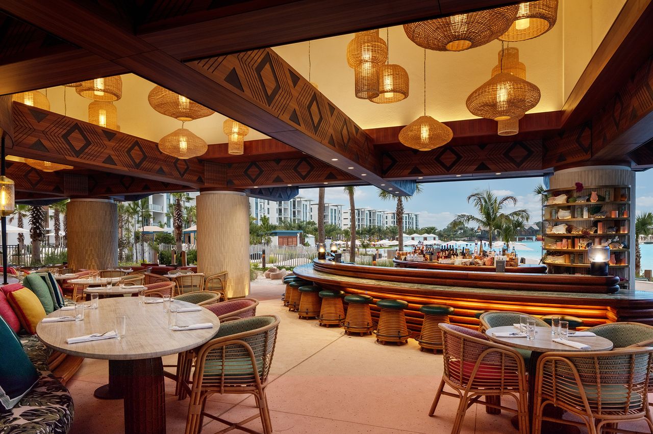 An upscale restaurant interior with outdoor views of a resort and pool area