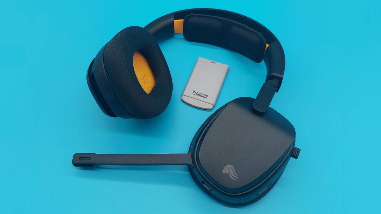 The GHS Wireless InfinitePlay seen from various angles on a blue background. This is a wireless gaming headset from Glorious. It is black all over, save for a few subtle orange accents.