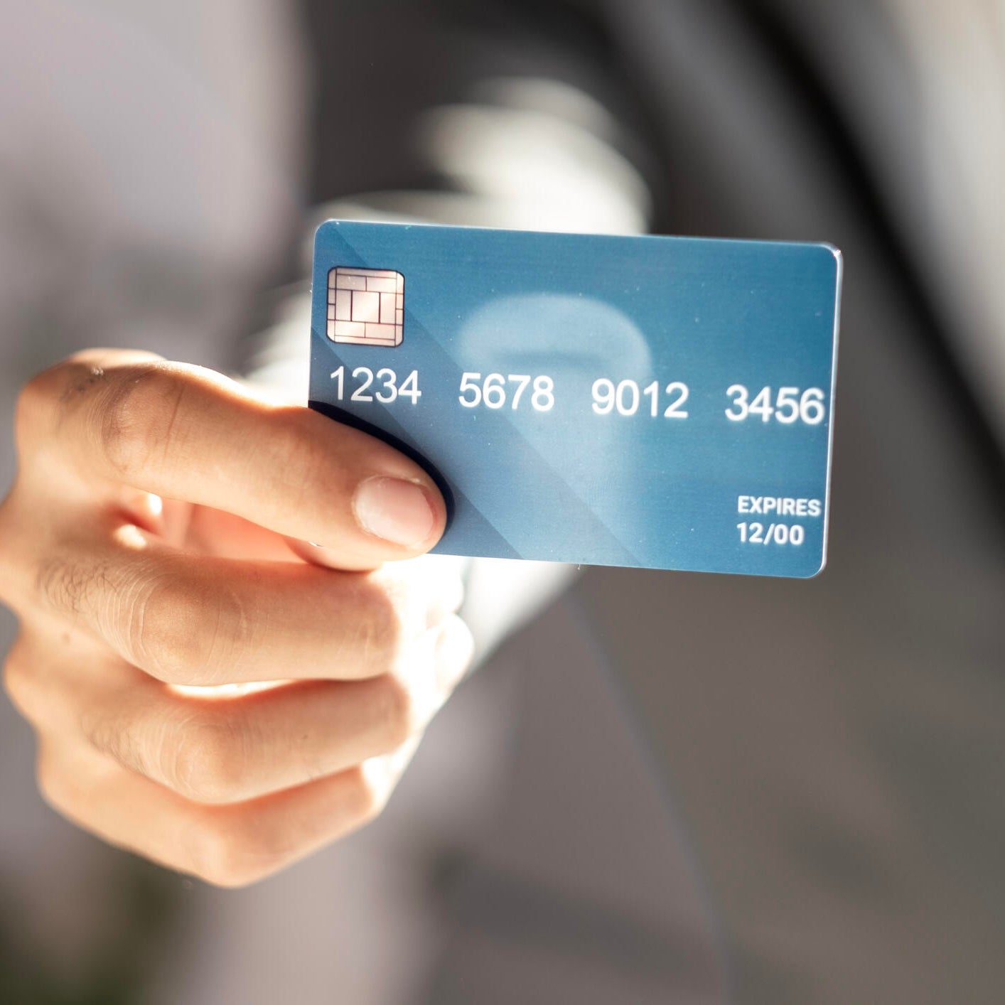 unrecognizable businessman in suit showing credit card