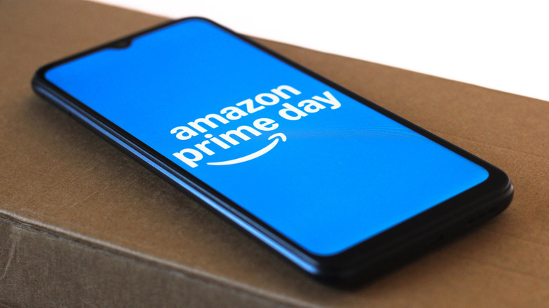 Amazon Prime Day logo on a blue screen displayed on a smartphone while lying on a wooden ledge