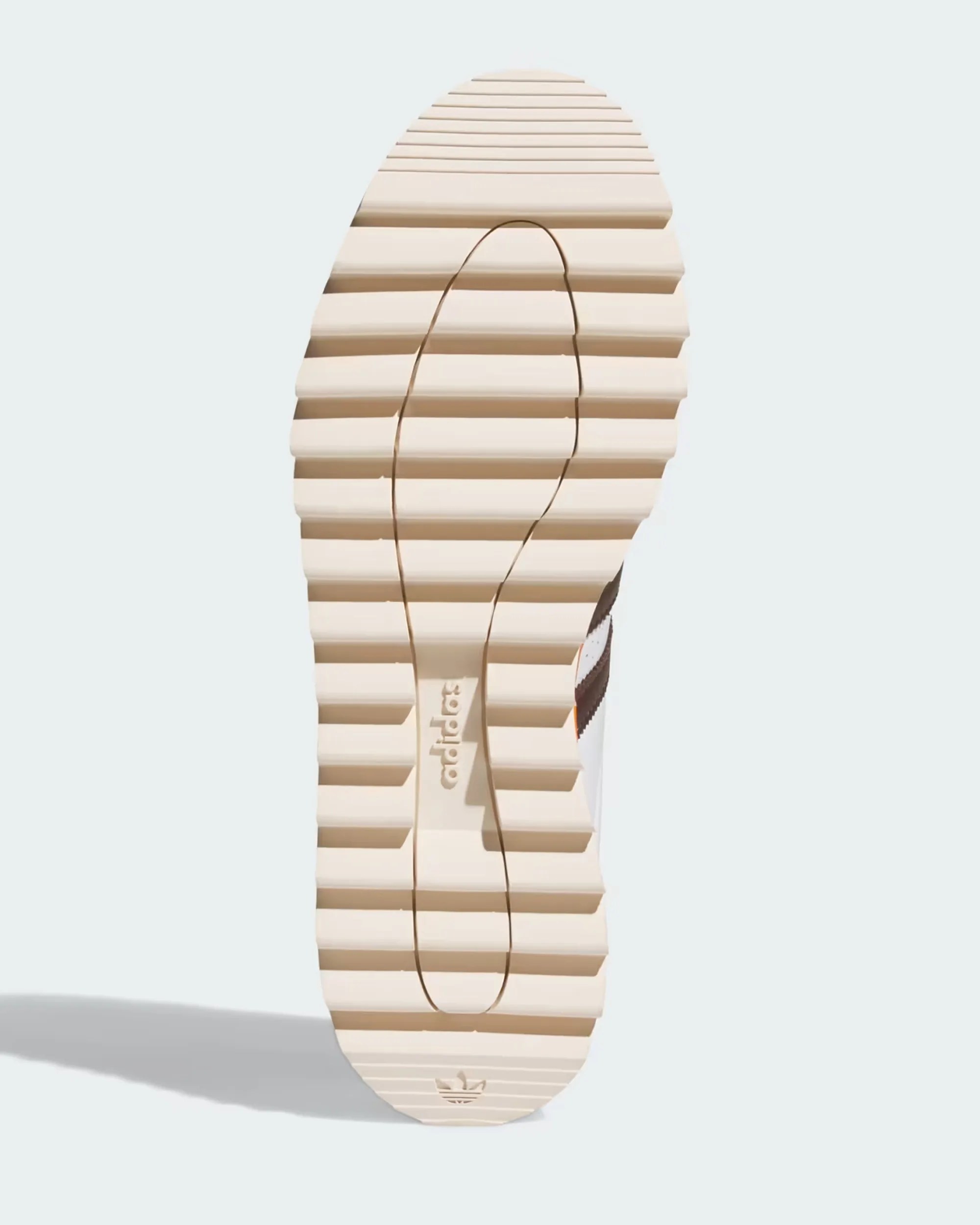 Beige Adidas shoe sole with horizontal grooves and Adidas logo near the heel.