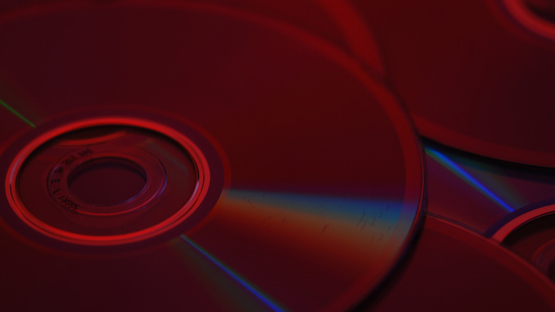 A collection of discs are shown in close up under a vibrant red light.