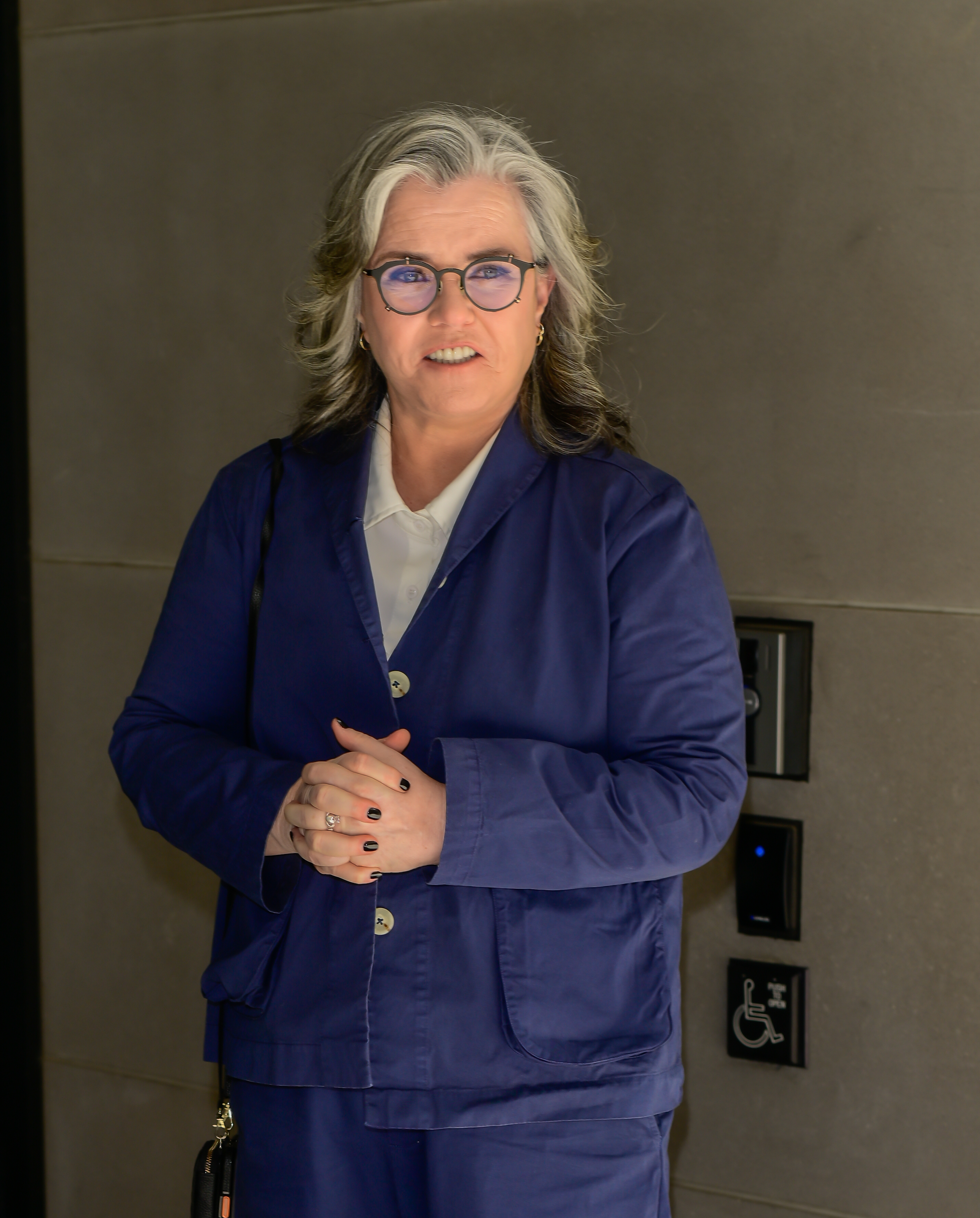 Rosie O'Donnell in a blue suit with a white shirt.