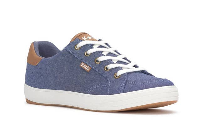 Casual sneaker in a denim-like texture with white laces and a white sole. Features a small brand tag on the side