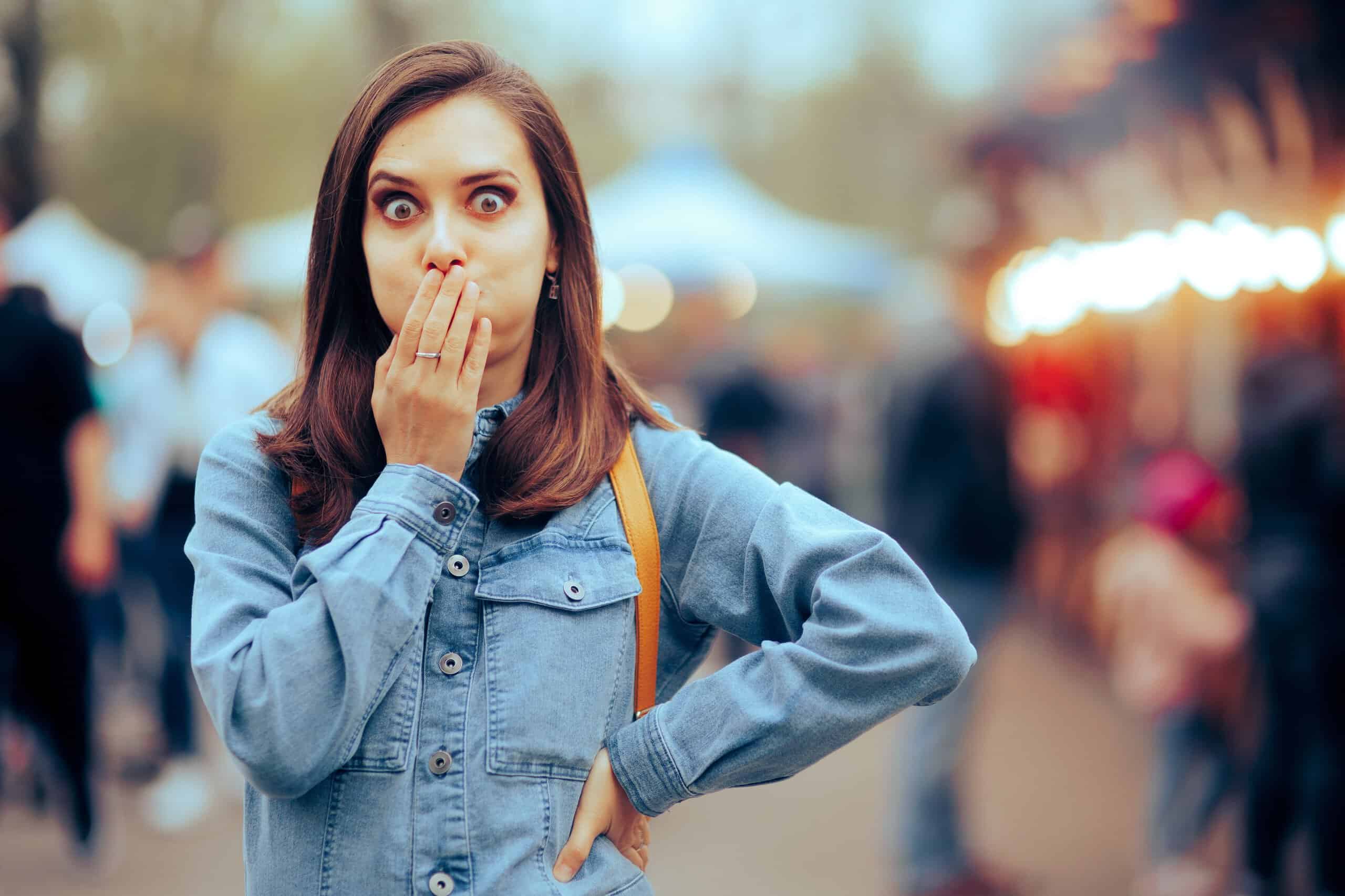 Woman feeling Sick Covering her Mouth at Local Funfair. Ill girl suffering from indigestion after eating some stress food