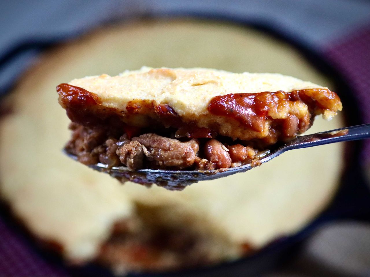 Close up of potato topped casserole bite on spoon