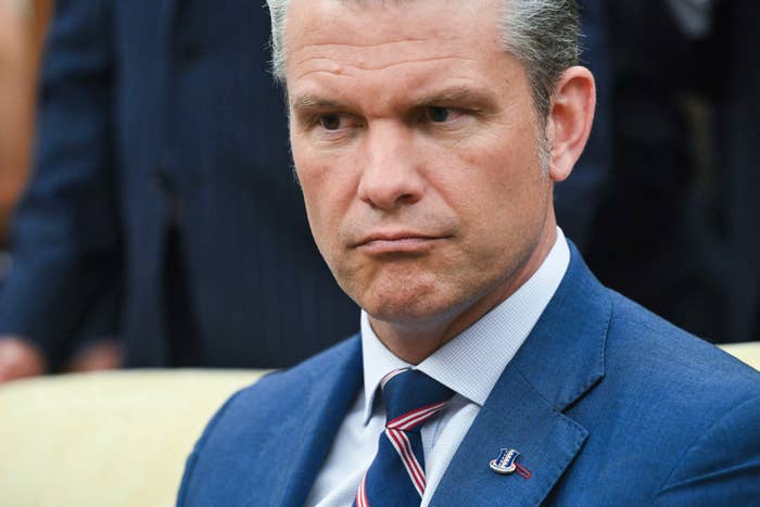 Person in a suit with a striped tie, looking intently