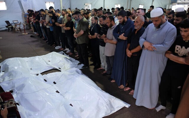 Mourners pray over the bodies of Palestinian Adham Nesman and his family, who were killed in an Israeli airstrike, during their funeral in Gaza city, July 18, 2026. (AP Photo/Jehad Alshrafi)