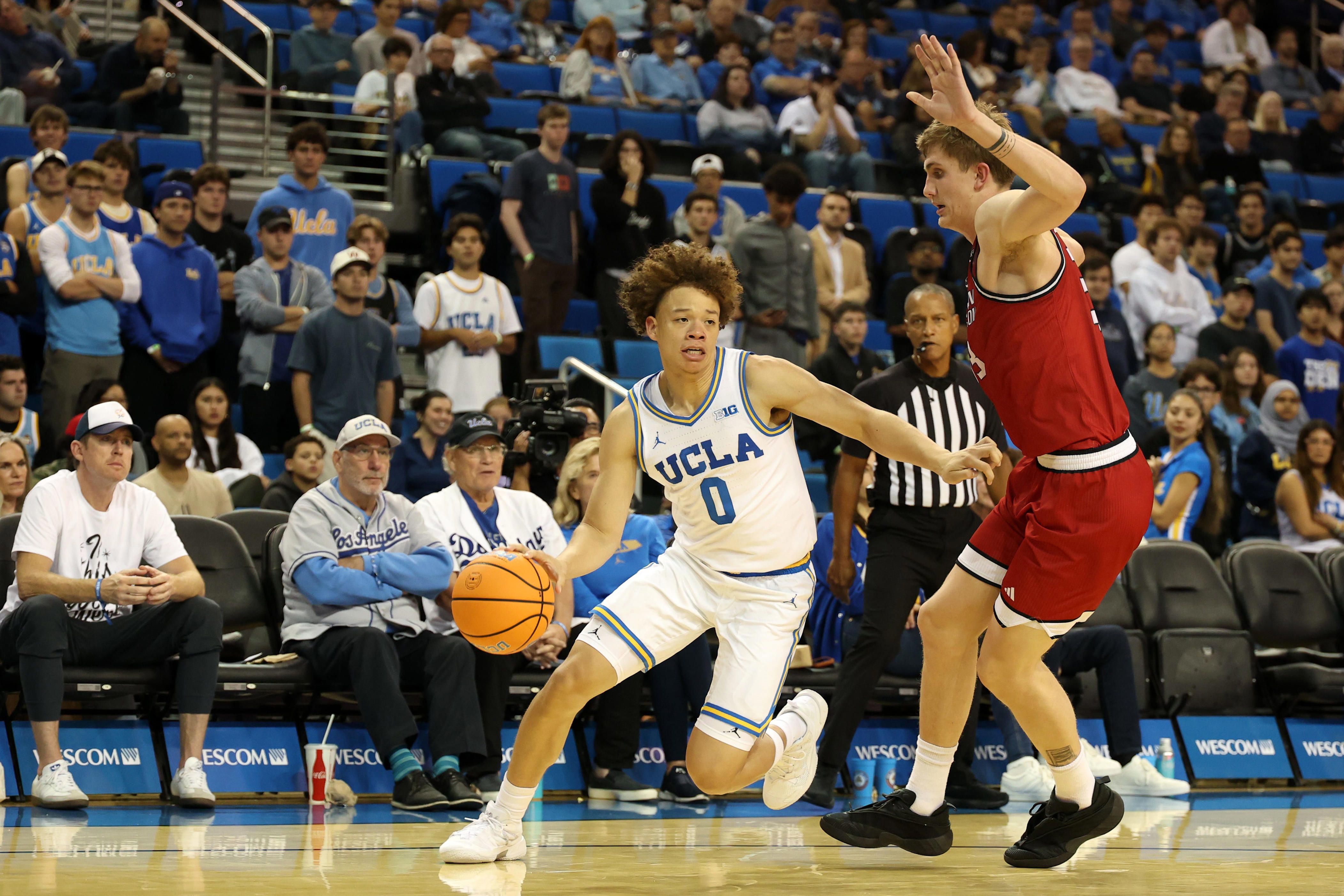 Nov 3, 2025; Los Angeles, California, USA; UCLA Bruins guard Trent Perry (0) dribbles the ball against Eastern Washington Eagles forward Emmett Marquardt (33) during the second half at Pauley Pavilion presented by Wescom Financial. Mandatory Credit: Kiyoshi Mio-Imagn Images