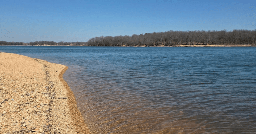 Clear blue water and a pebble beach at Fellows Lake, a popular Missouri outdoor recreation spot.
