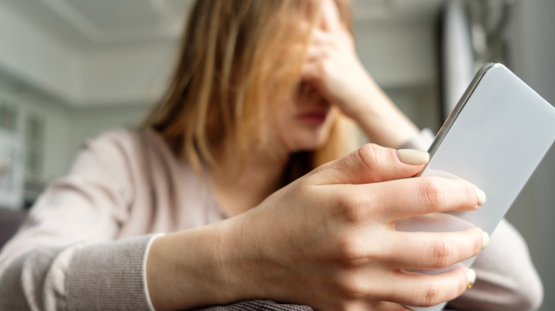 Frustrated woman holding a smartphone