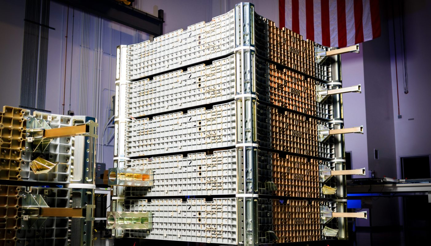 a stack of rectangular satellites is stacked in a dimly lit room