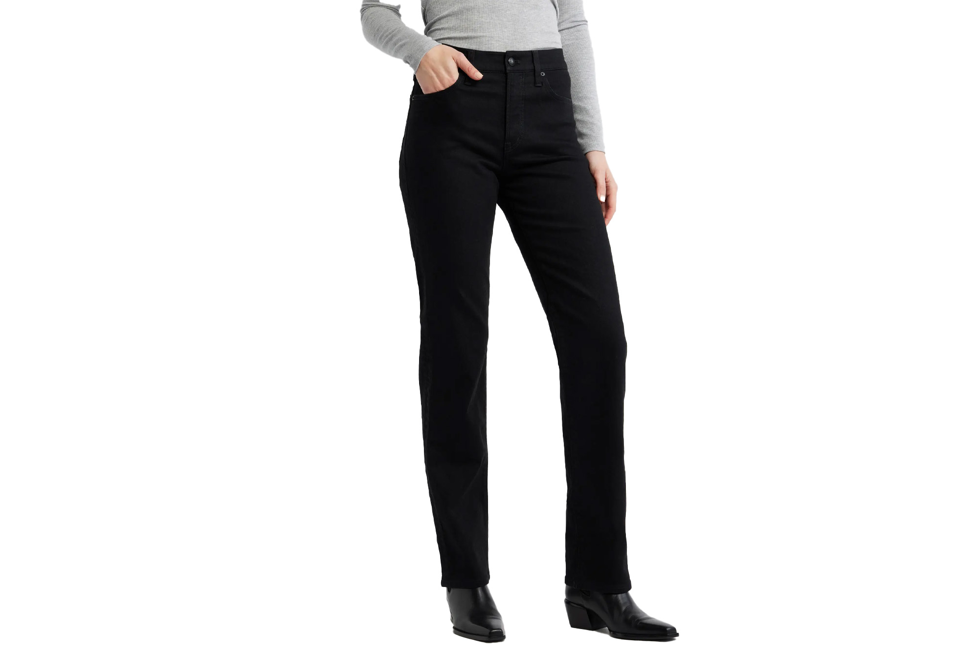 A person wearing black jeans with a gray long-sleeved shirt and black boots, with one hand in a pocket.